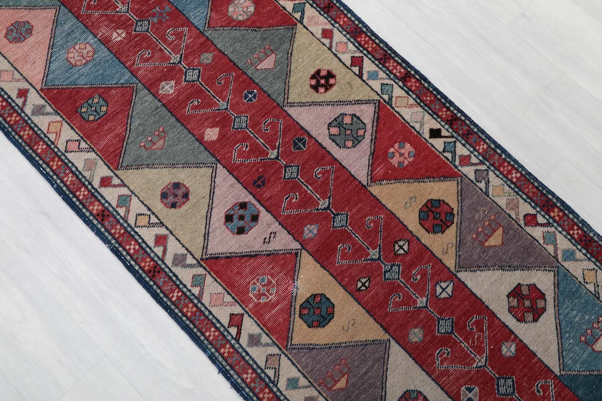 Overhead detail of the intricate tribal motifs and color variations within the rug's pattern