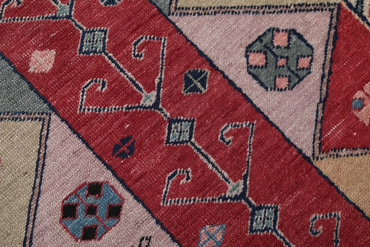 Close-up showing the low wool pile texture and hand-knotted details of the rug