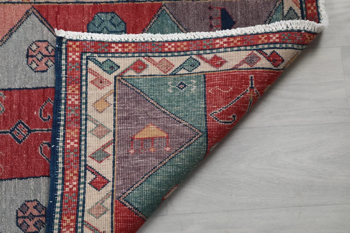 Another view of the rug's folded corner, emphasizing the hand-knotted construction and material