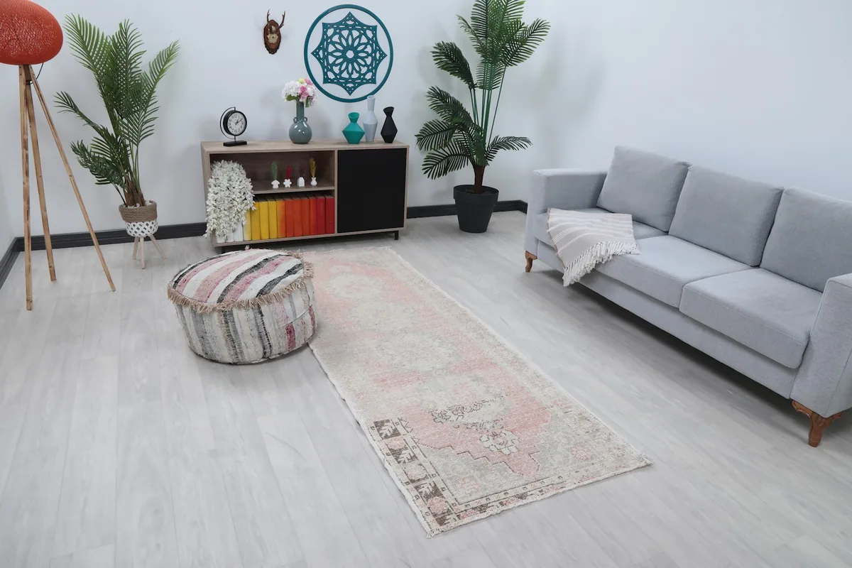 Angled view of the runner rug in a room setting with light flooring and furniture.