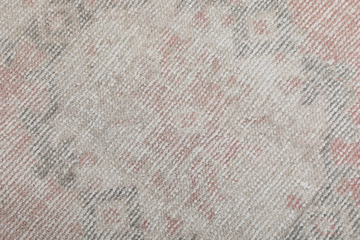 Close-up of the low wool pile, showing the hand-knotted texture and muted color variations.