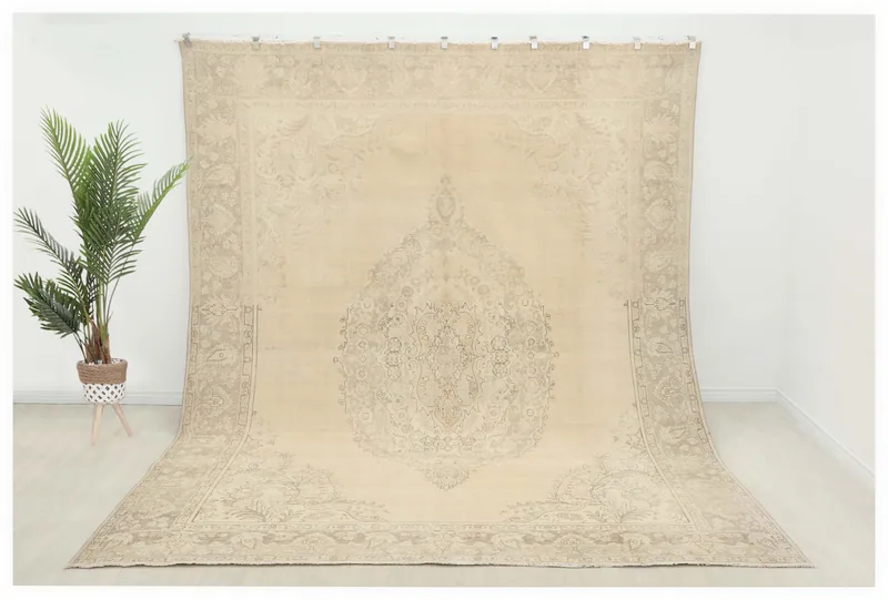 Full top view of the 9'7" x 12'3" ivory floral medallion vintage Anatolian area rug on a white background.