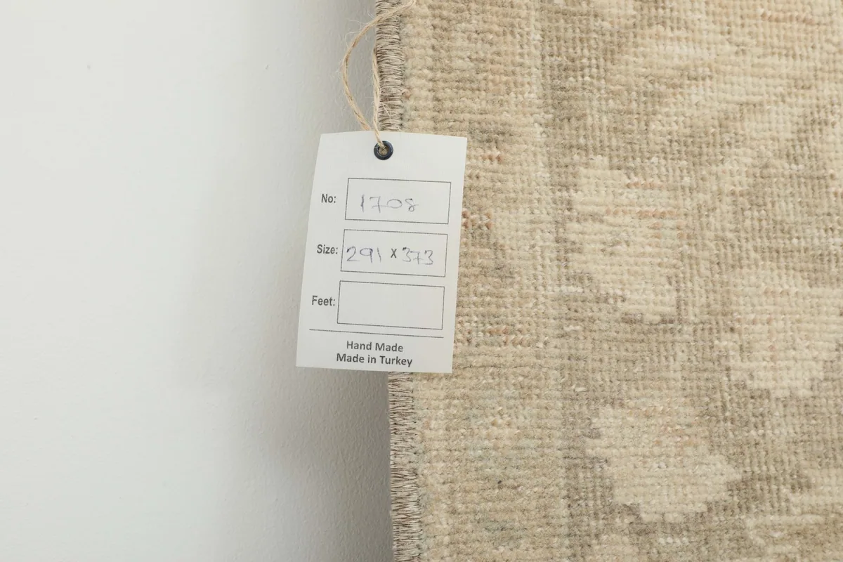 View of the back of the rug with a tag showing size and 'Hand Made in Turkey'.