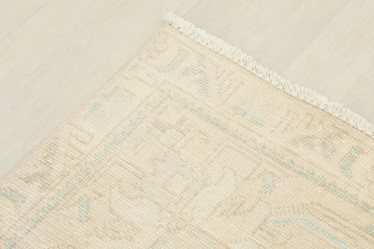 Detail of the rug's border design and edge, showing the hand-knotted construction
