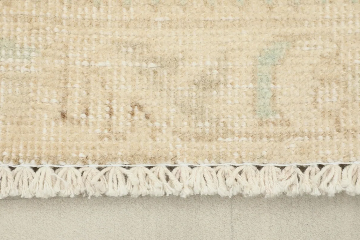 Close-up of the short, delicate fringe at the end of the vintage wool rug