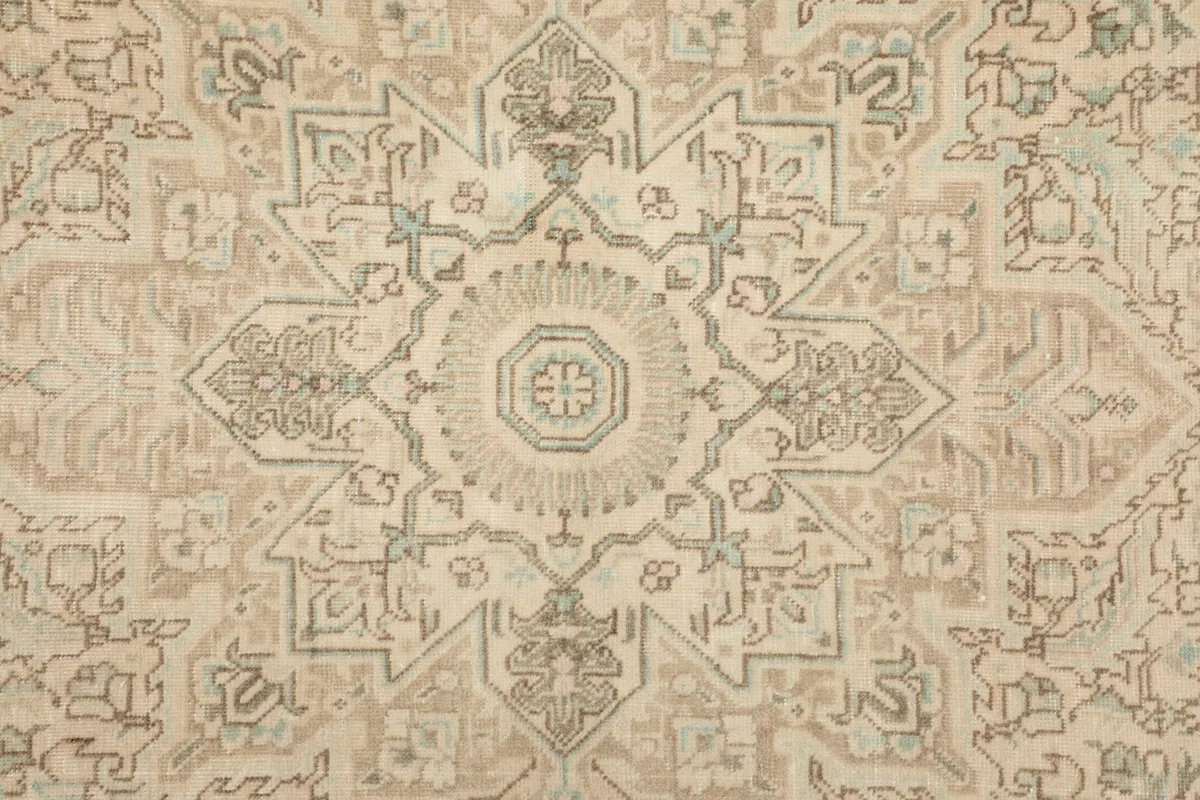 Detailed view of the central medallion design, showing intricate beige, gray, and blue motifs