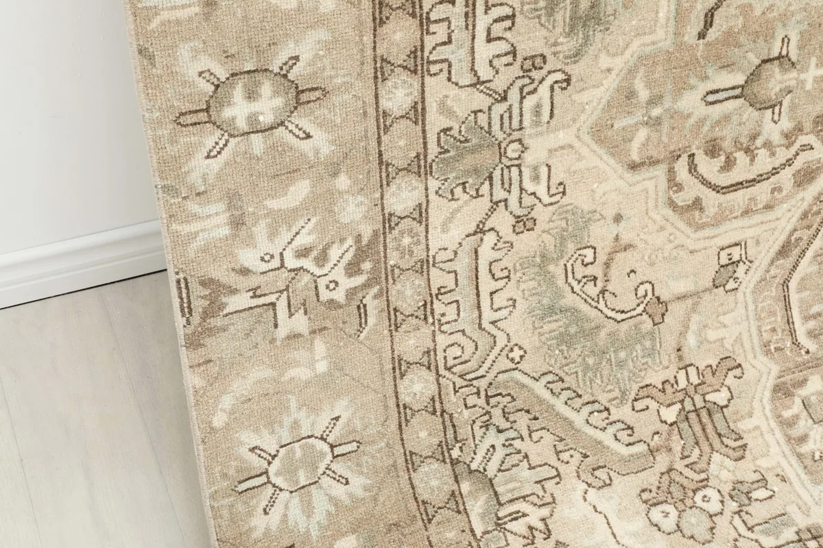 Close-up detail of the rug's border pattern, showing geometric motifs in beige and gray.