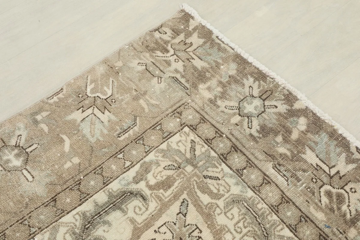 Corner detail of the rug, showing the main border and field patterns, and the soft fringe.