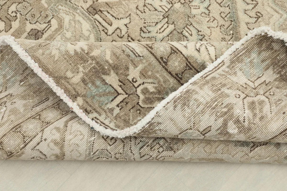 Close-up of a folded edge, showing the tight knotting and the quality of the wool and cotton materials.