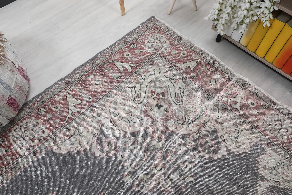Corner view of the rug, showcasing the faded rose and ivory motifs