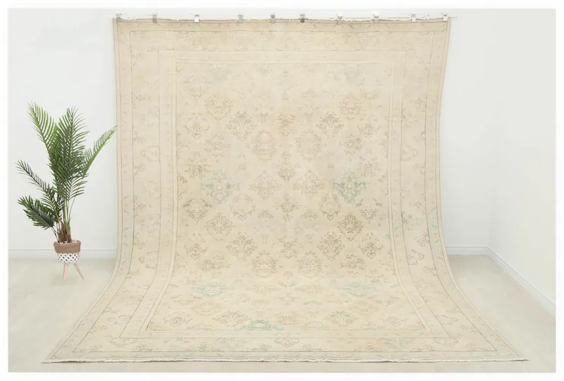Full overhead view of the ivory and beige vintage Anatolian area rug with floral patterns