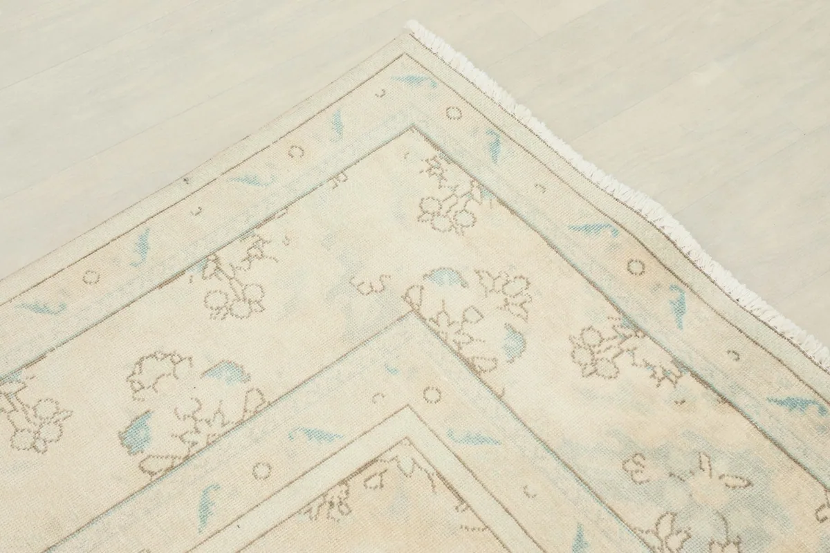 Corner detail of the rug's geometric border and inner floral patterns