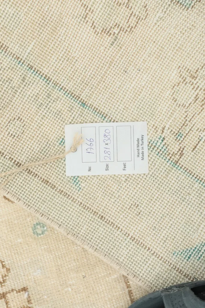View of the rug's cotton foundation and a tag indicating its hand-made origin in Turkey