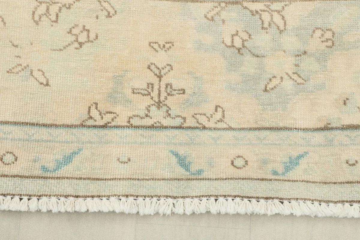 Close-up of the rug's short, natural fringes and a section of the border design