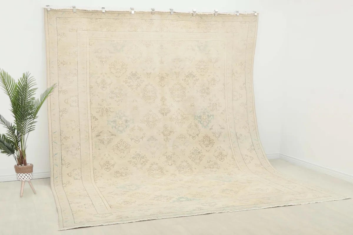 Slightly angled overhead view of the large ivory rug, showing its full design and subtle color variations