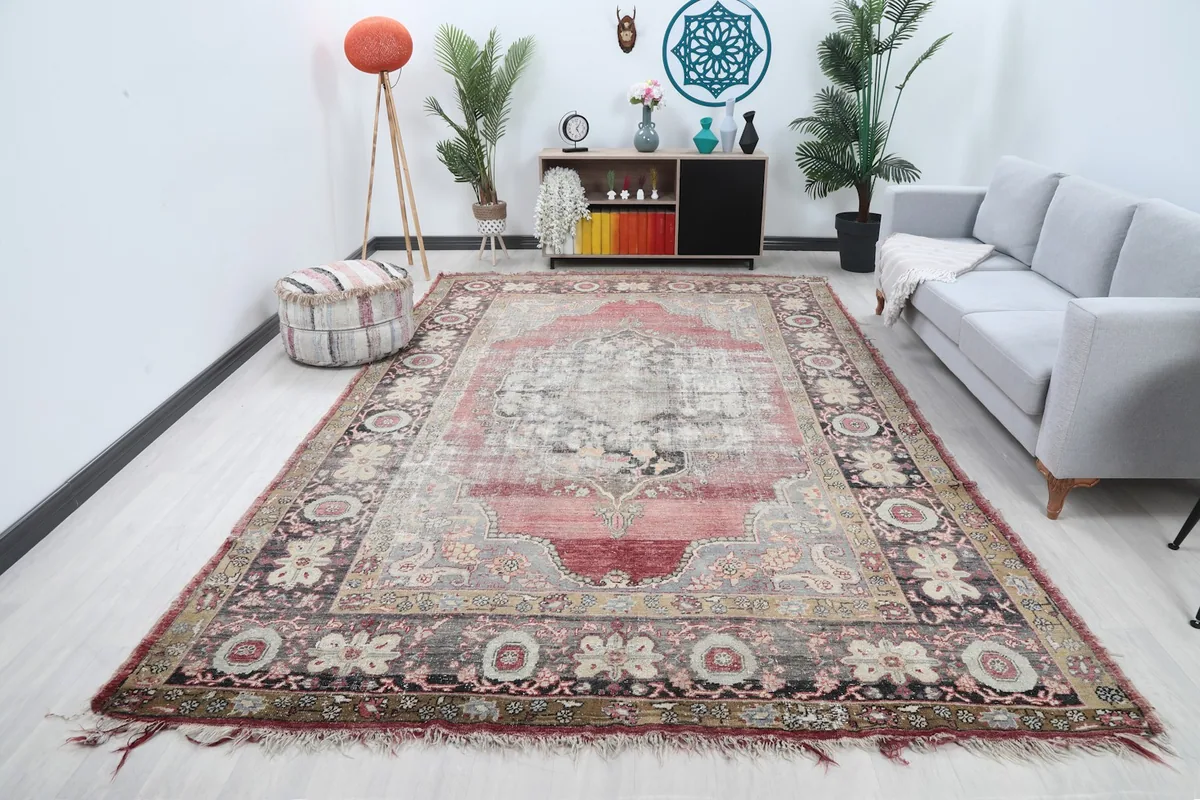 Vintage rose and gray rug displayed in a bright living room setting with a sofa and decor