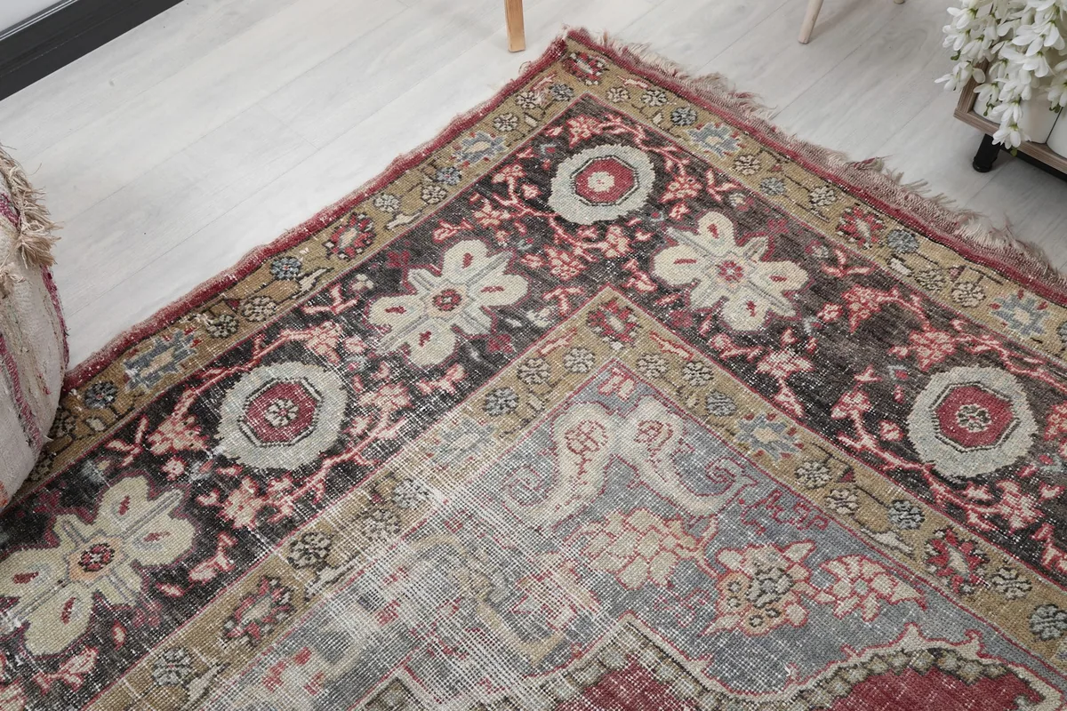 Corner detail of the rug, showing the blend of rose, gray, and black motifs