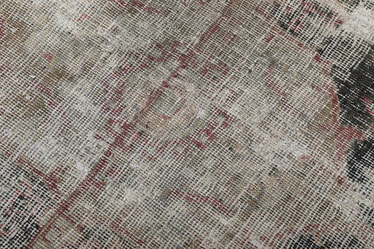 Texture detail of the low pile and visible cotton foundation due to wear