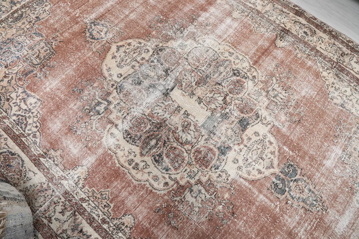 Close-up of the central medallion with faded rust and ivory tones