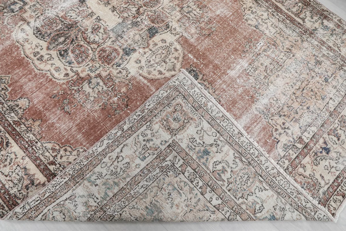 Corner of the rug folded back, revealing the hand-knotted cotton foundation