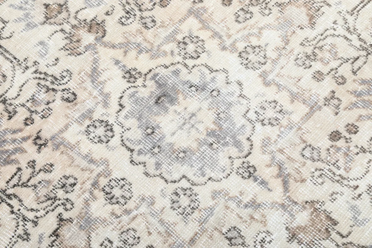 Detailed view of the wool pile texture and specific floral and geometric designs in the field.