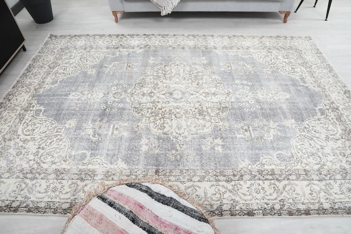 Overhead view of the rug laid out, showing the full extent of its gray and ivory design.