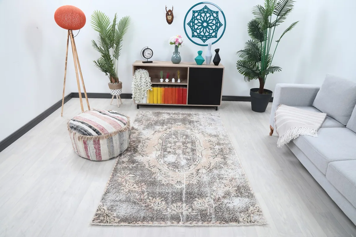 Vintage Anatolian rug in a living room setup with a gray sofa and wooden furniture