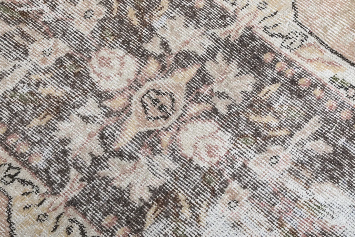 Close-up of the distressed wool pile, showcasing the hand-knotted texture and muted colors