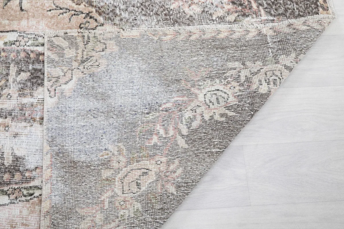 Corner of the rug turned over to reveal the hand-knotted construction from the back