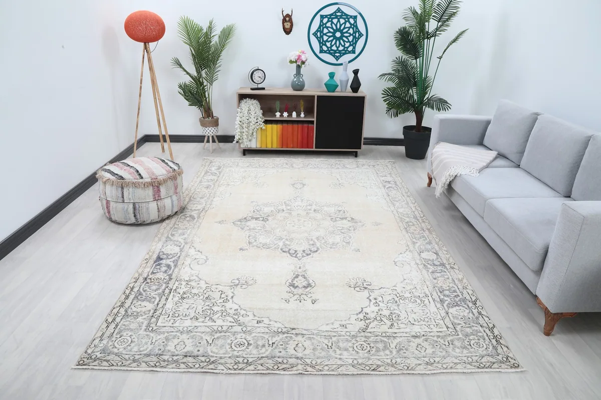 Ivory and charcoal vintage rug displayed in a bright living room setup with a gray sofa.