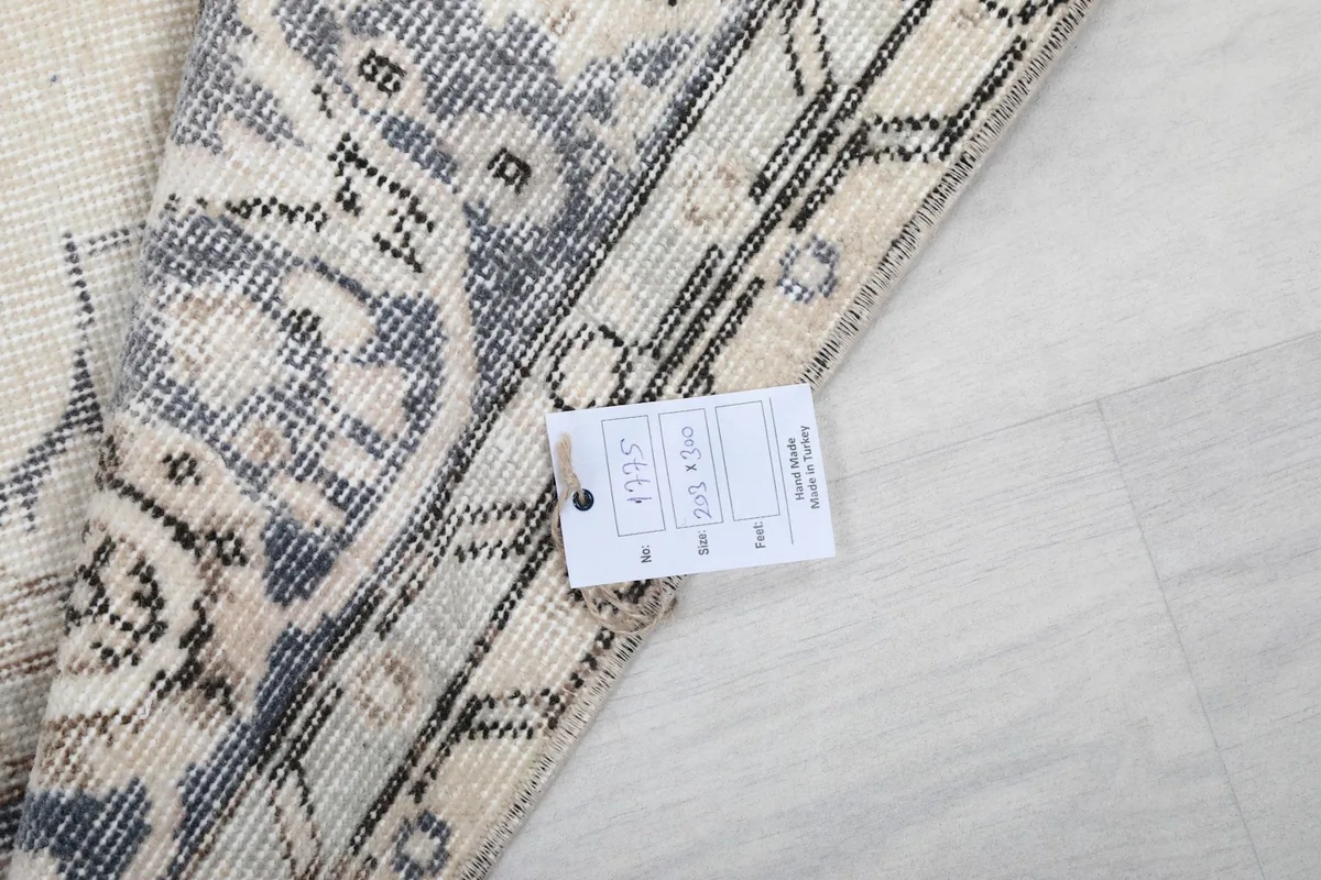Underside of the rug with a label, showing the hand-knotted cotton foundation.