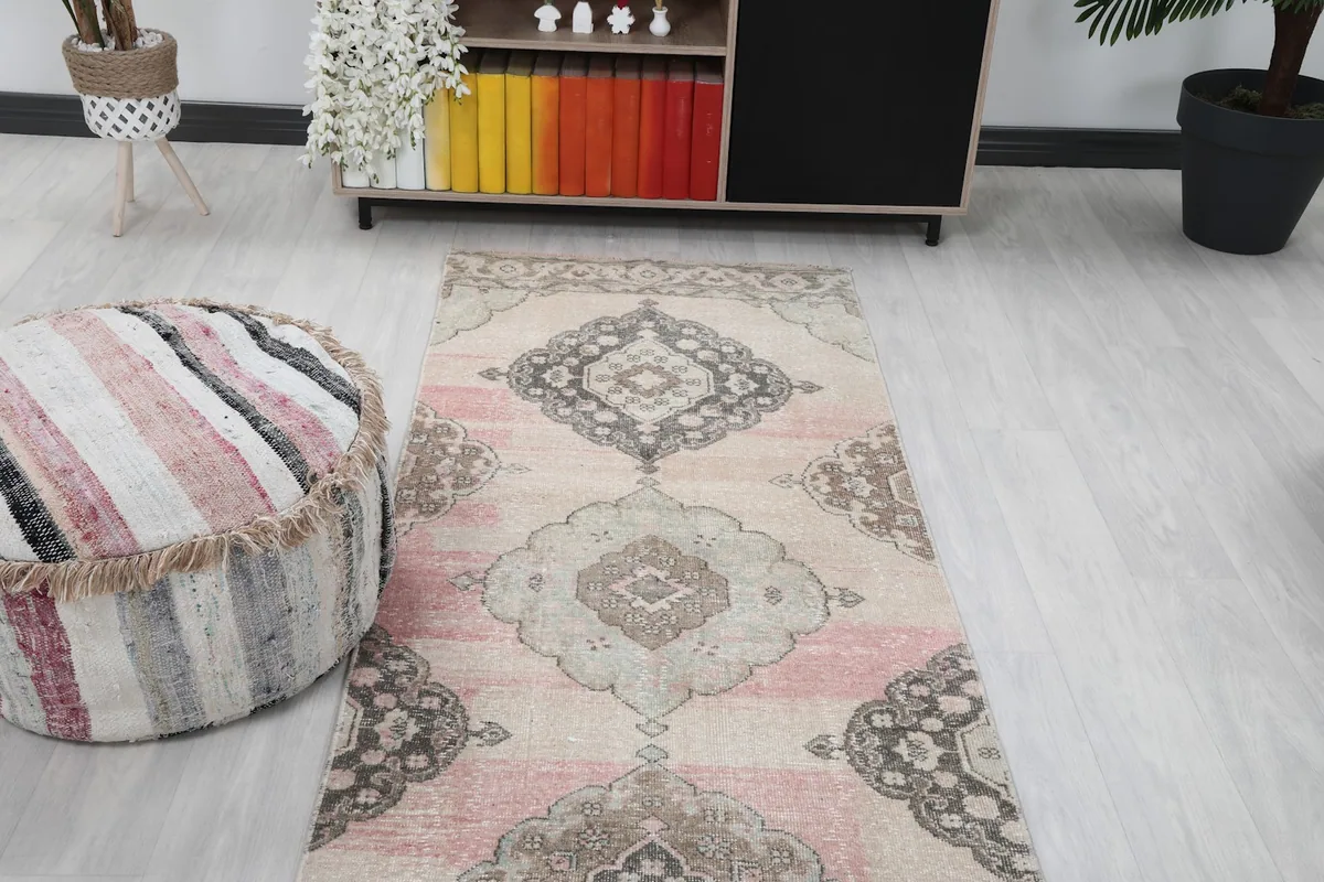 Overhead angled view of the runner rug's pattern alongside a decorative ottoman.