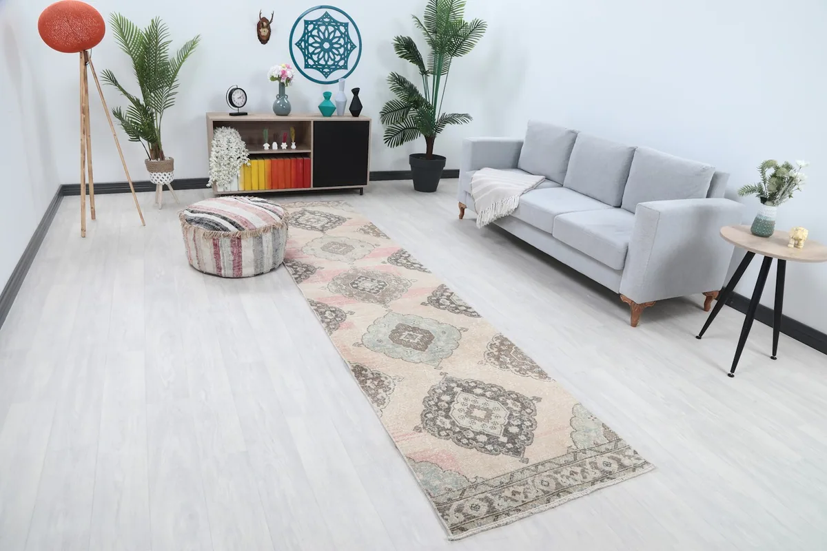 Angled view of the ivory and pink vintage runner rug in a modern living space.