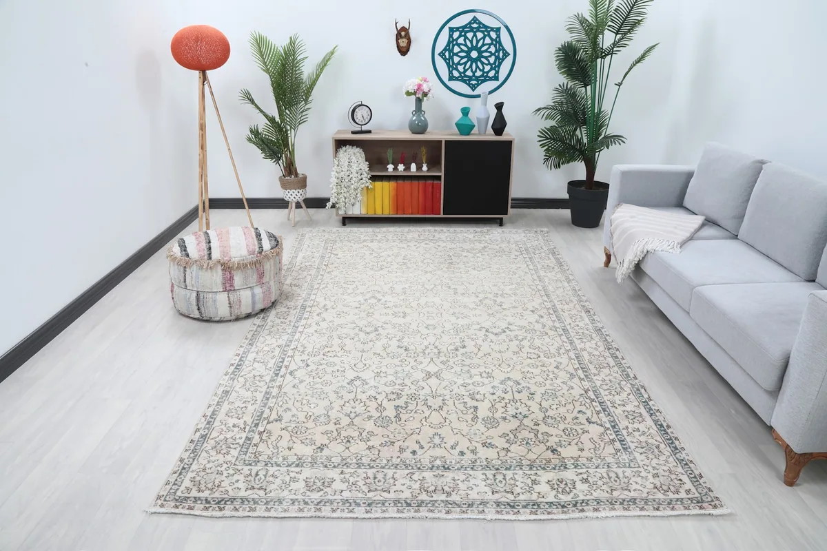 Beige vintage rug displayed in a bright living room setup with a gray sofa