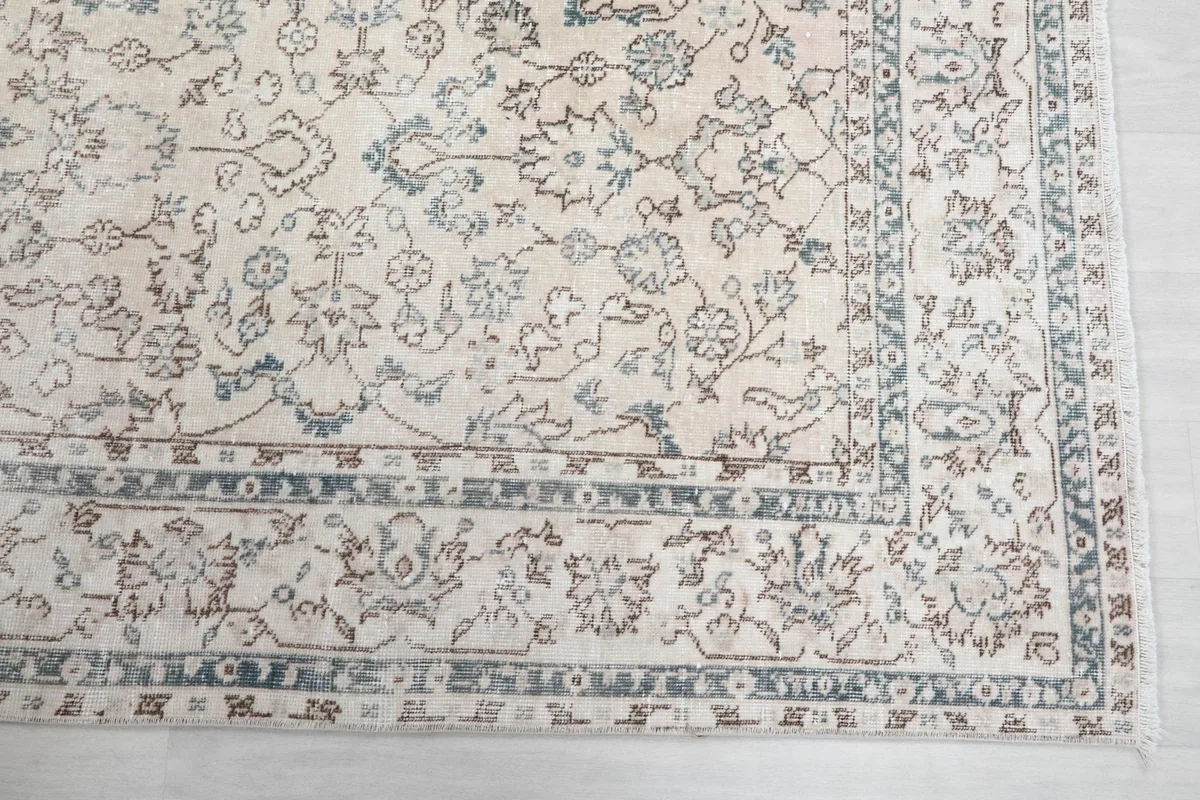 Detailed view of the rug's border design with geometric and floral elements in blue and brown