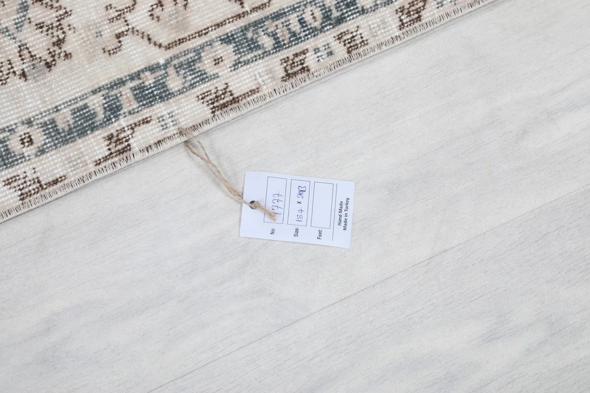 Rug tag displaying size and origin details on the floor next to the rug