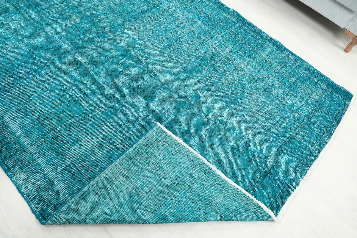The rug folded back to show the underside and the transition from pile to foundation