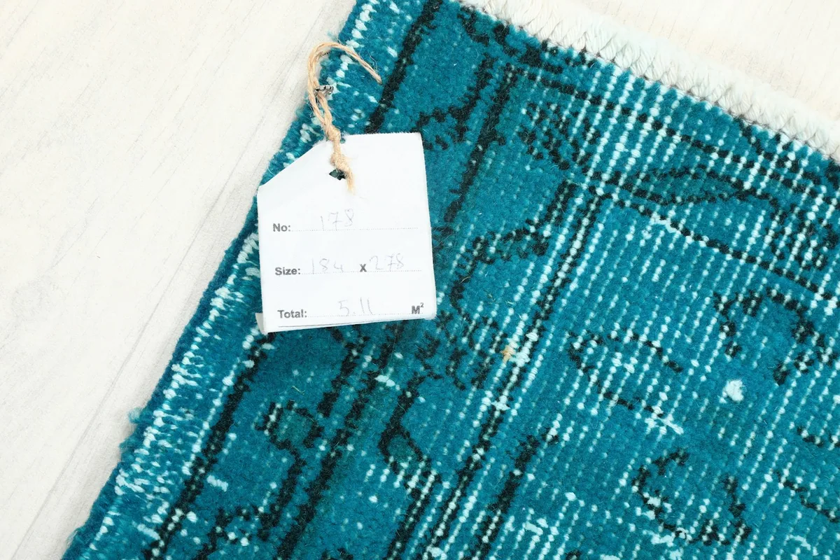 Corner of the rug with the product tag, showing size and material information