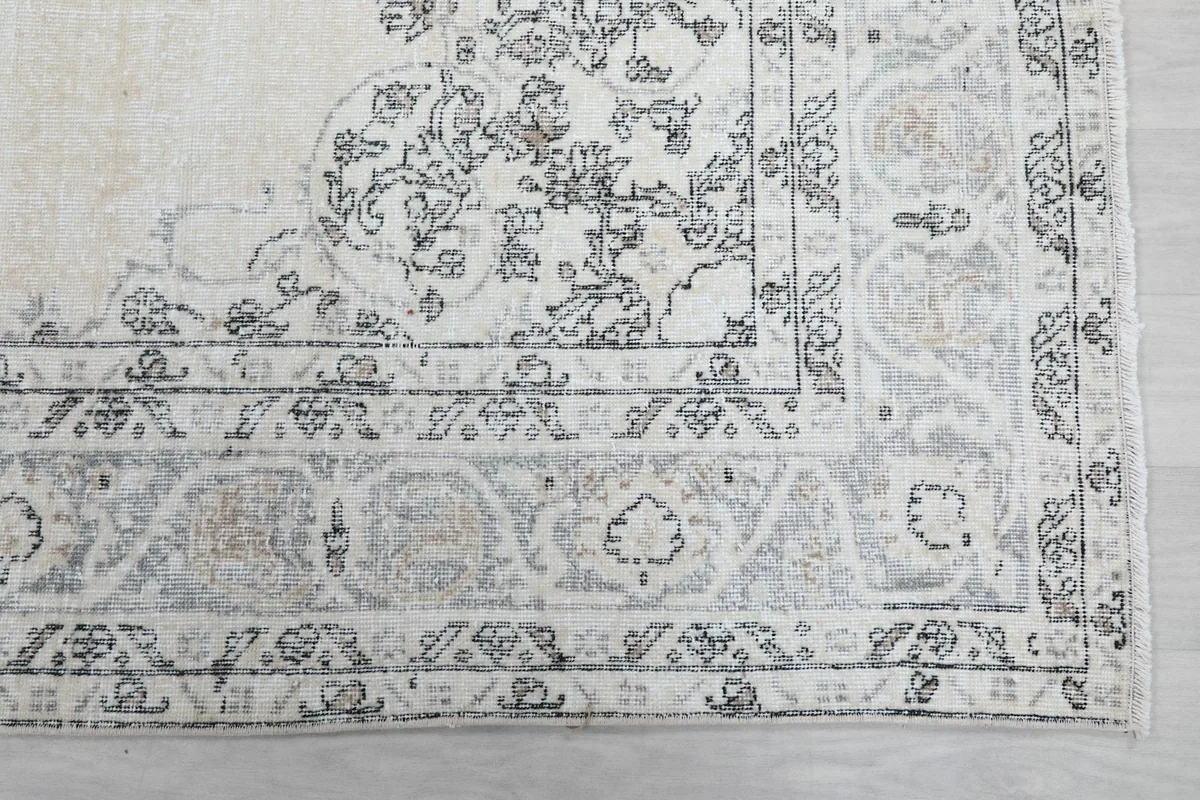 Close-up of the rug's corner border, showing intricate floral and geometric patterns