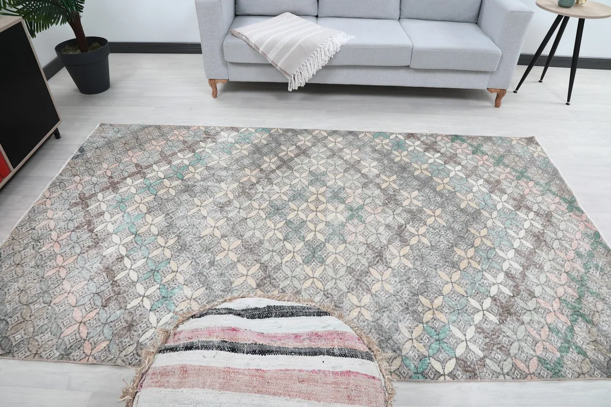 Full room view with the rug as a central element, featuring a gray couch and decorative items