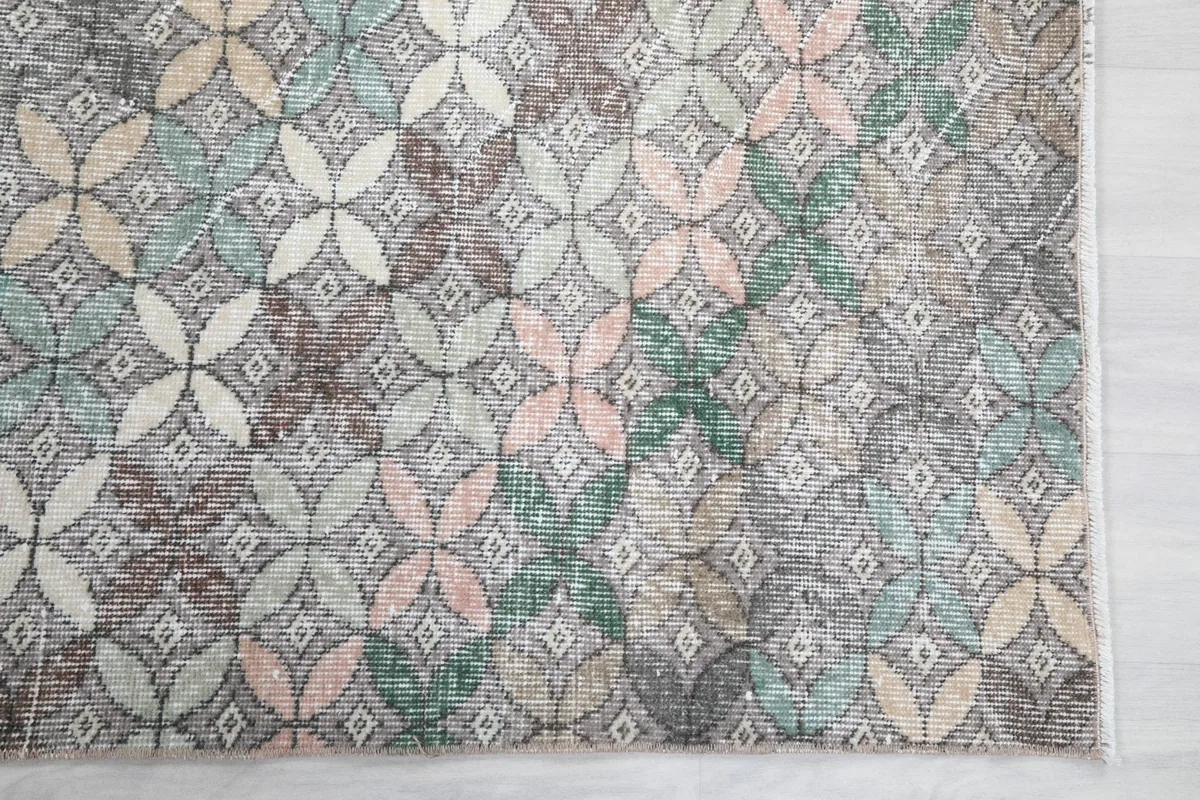 Detailed view of the repeating quatrefoil-like geometric pattern with blue, pink, and beige accents