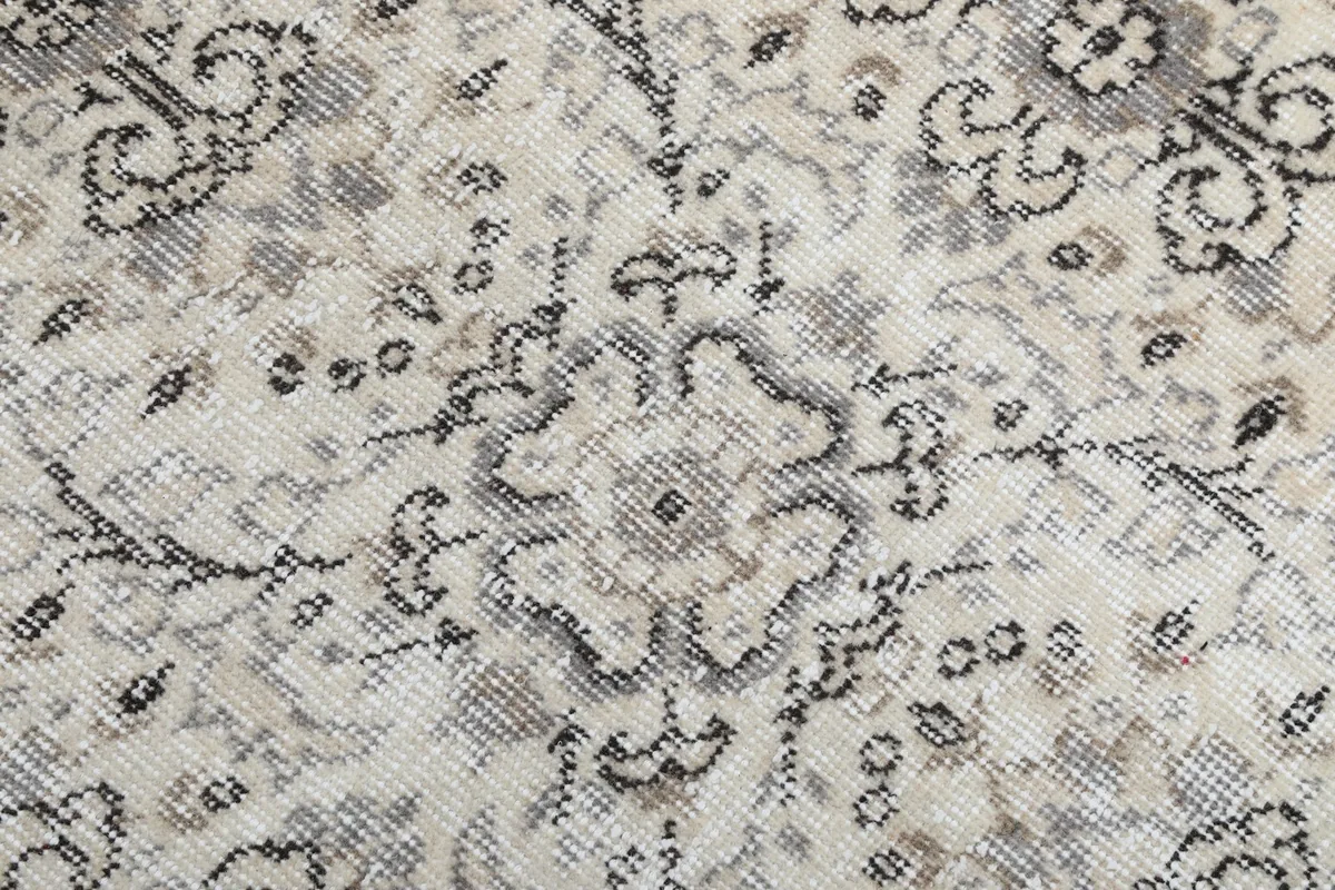 Close-up of a single geometric motif, showing the subtle color variations and wool texture