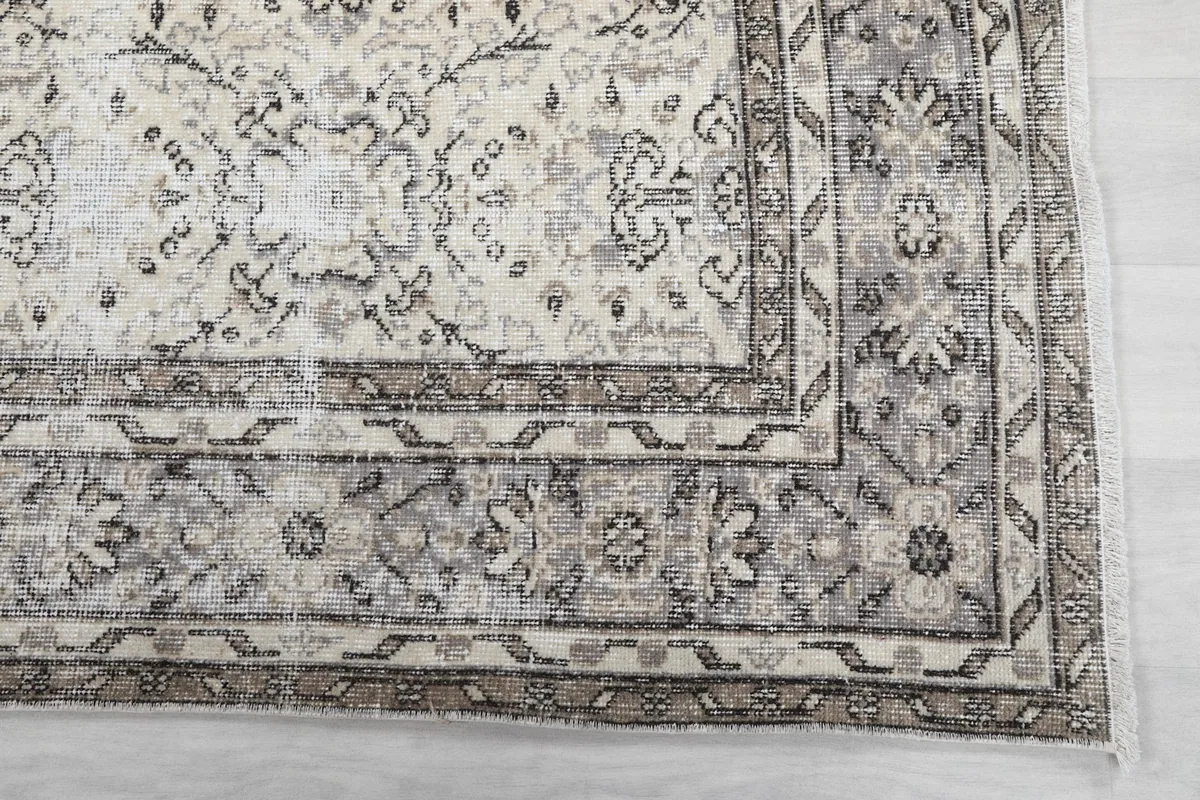 Detail of the intricate gray and tan border pattern of the hand-knotted rug