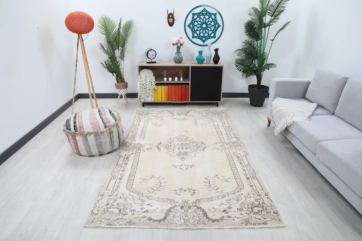 Vintage ivory and charcoal Anatolian rug in a living room setting with a gray sofa