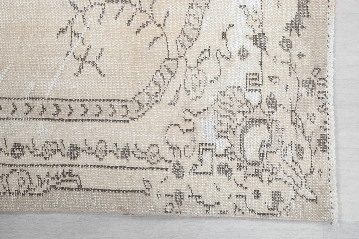 Close-up detail of the corner pattern and border on the ivory and charcoal rug