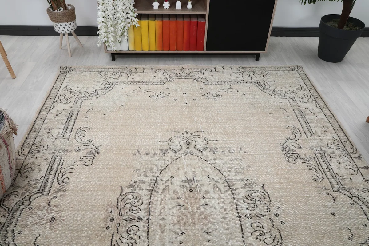 View of the rug from one end in a room, highlighting the upper border and faded colors