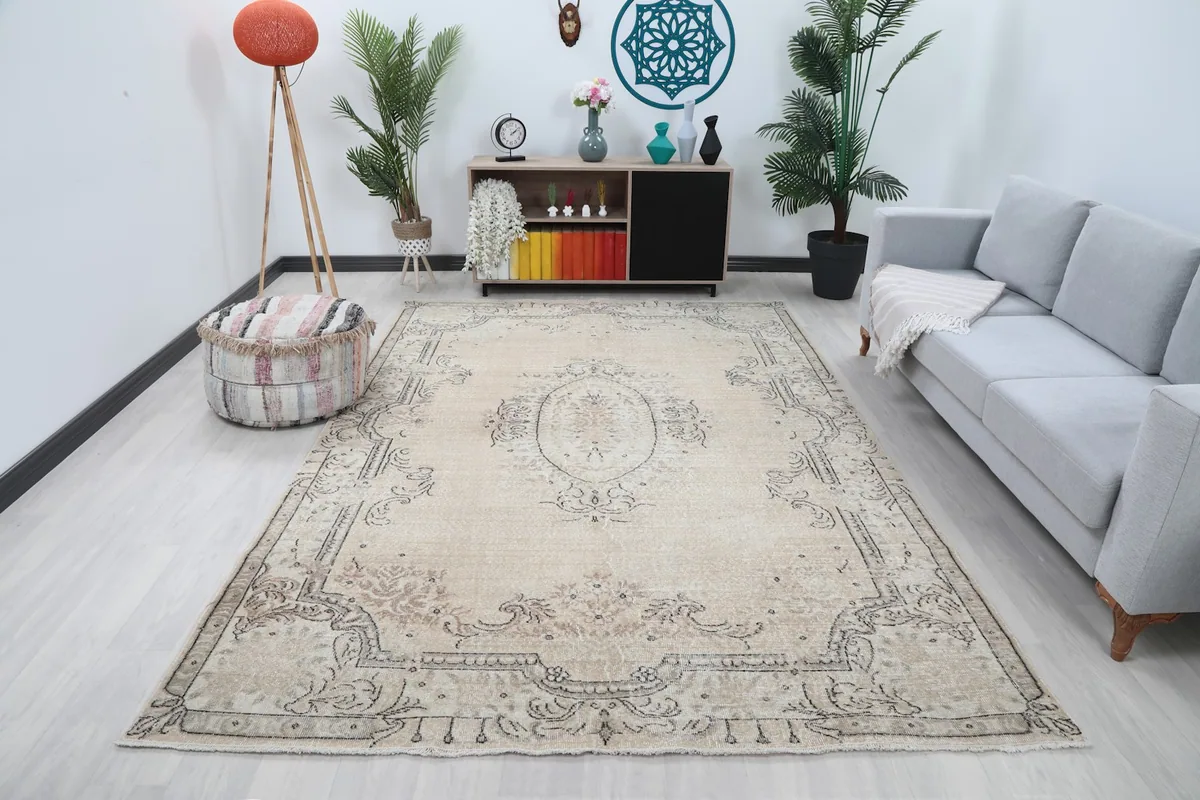 Vintage area rug displayed in a living room setting with a light gray sofa