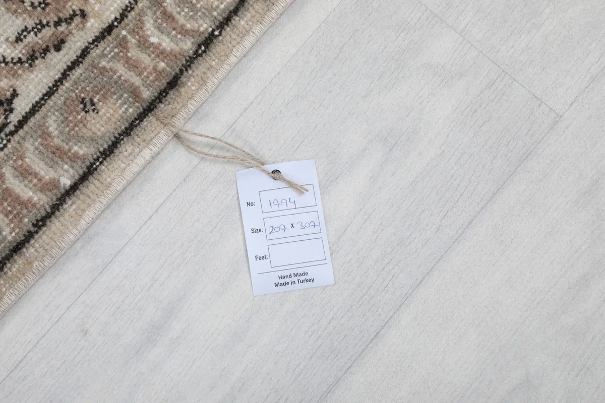 Product tag showing the rug's dimensions and 'Hand Made in Turkey' on a light floor