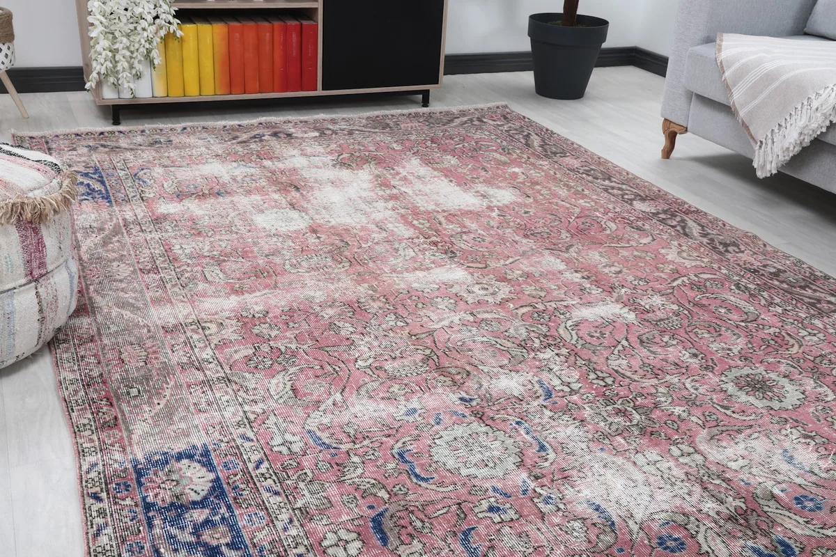 Close-up angle of the rose field and navy border of the vintage rug