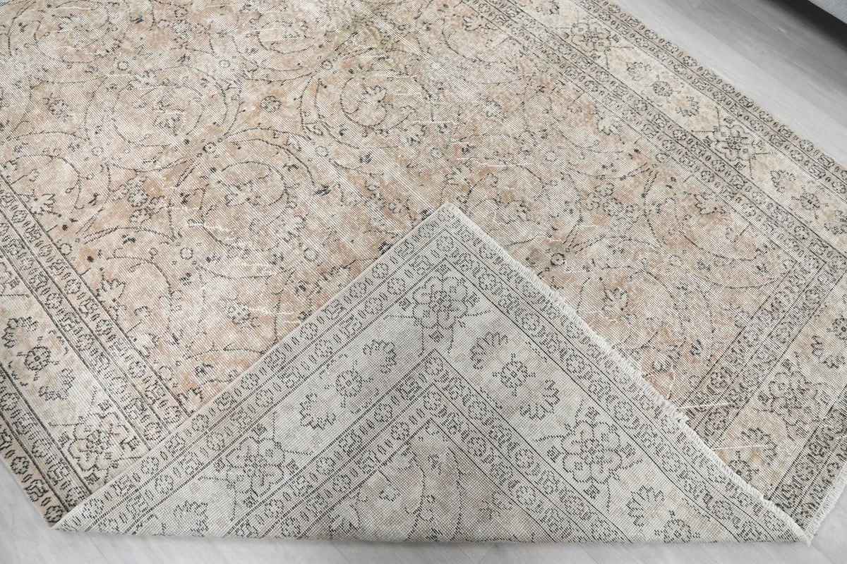 Corner of the rug folded back to show the cotton foundation and reverse side
